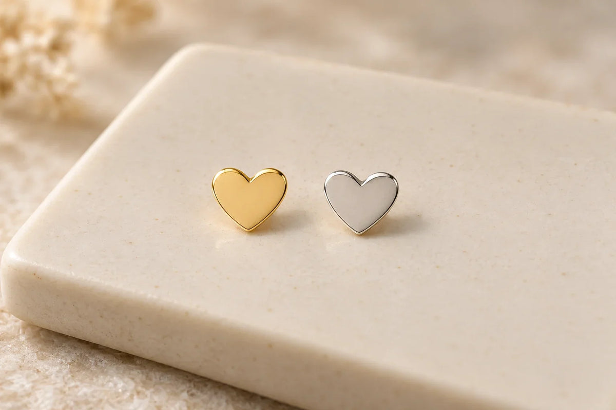 Illustration comparing two heart-shaped tooth gems, one in yellow gold and the other in white gold.